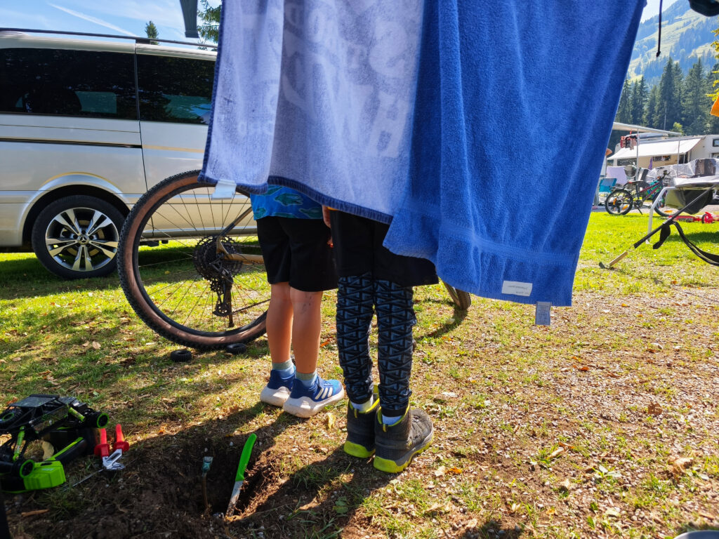 Zwei Jungs auf dem Campingplatz, versteckt hinter Handtüchern