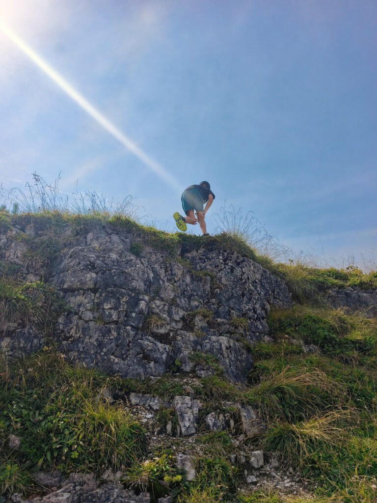Kind klettert auf Felsvorsprung