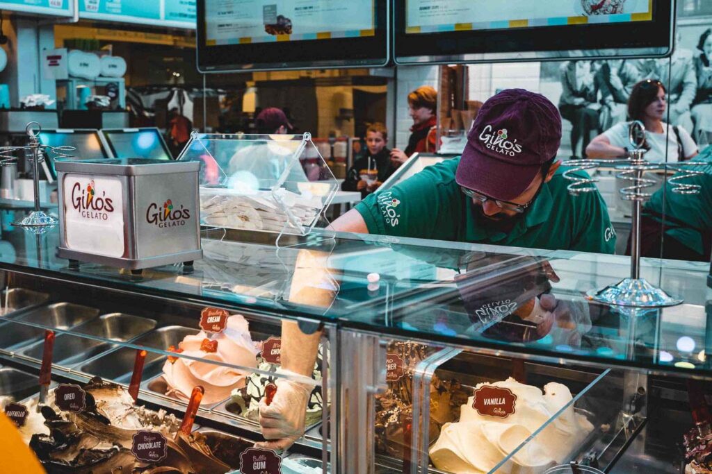 Eine Eistheke mit einem Mitarbeiter, der Eis portioniert